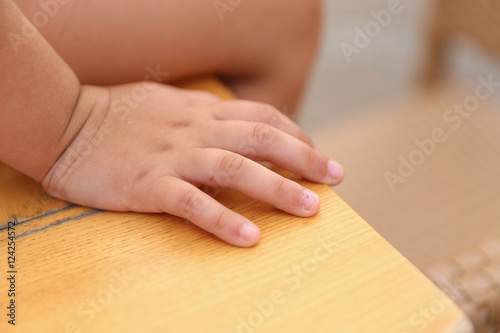 closeup of a child's hand sitting on a desk,