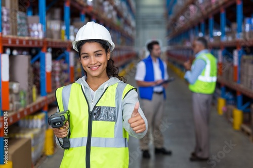 Obraz na plátně Female warehouse worker showing thumbs up sign