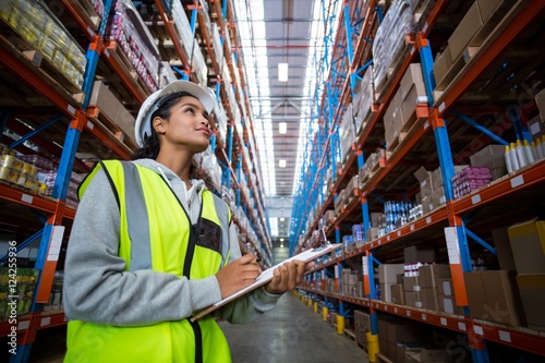 Female warehouse worker looking at packages