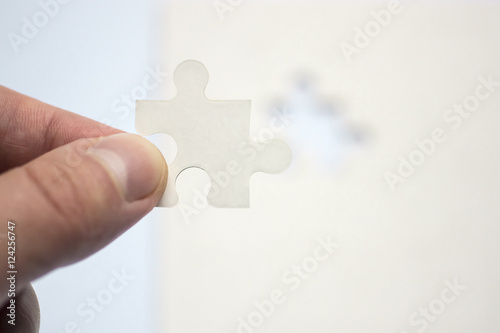 Hand holds suitable piece of puzzle
