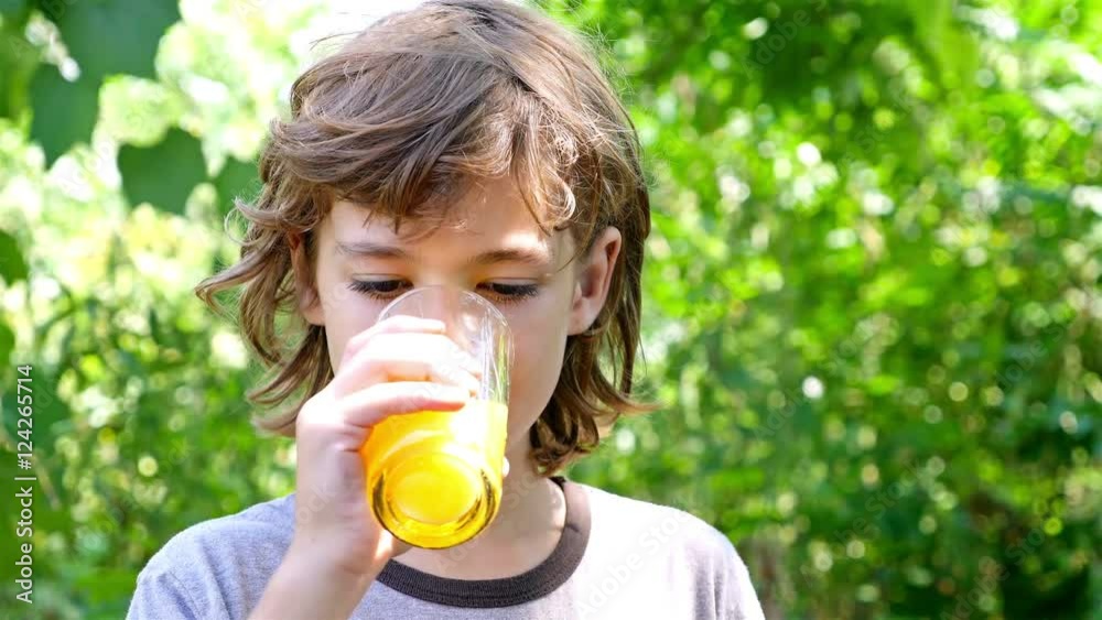 Boy is drinking orange juice outside Boy is drinking orange juice outside