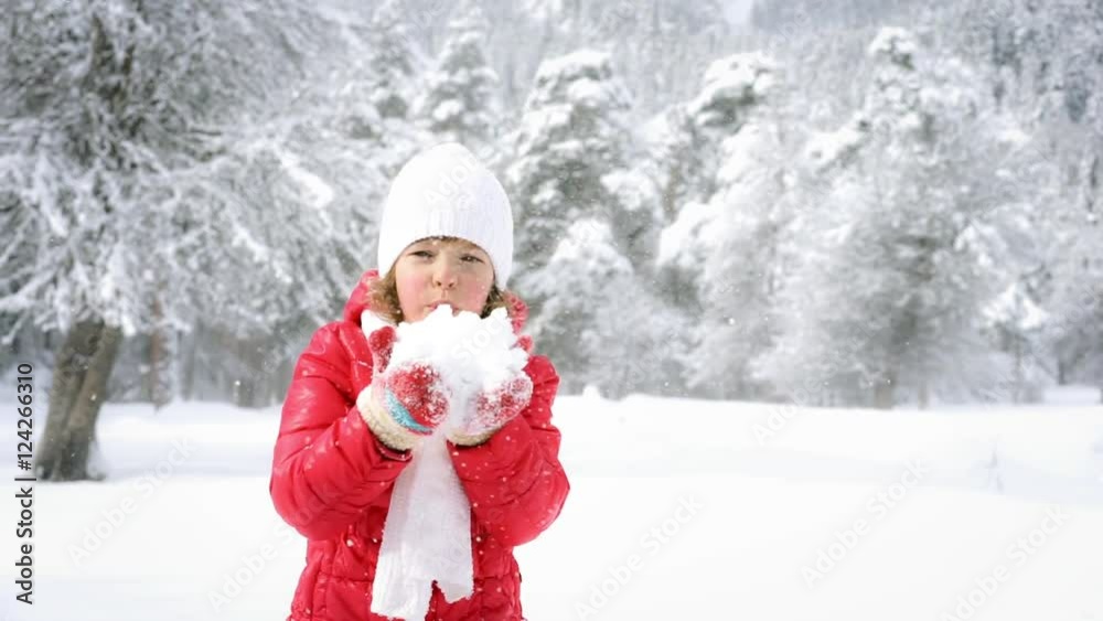 Funny child blowing snow in winter forest Funny child blowing snow in winter forest