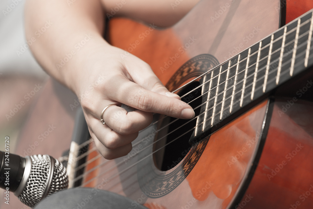 Fototapeta premium girl's hand playing guitar