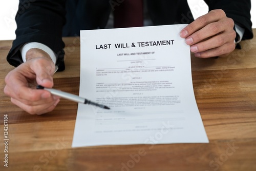 Mid section of businessman showing last will and testament form photo