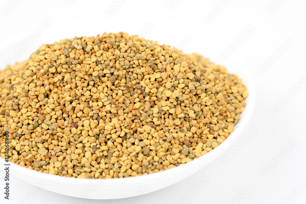 Closeup of bee pollen granules in white bowl/dish/container. Bee pollen great for immune system, energy, winter time. Food ingredient. For health, medicine. Isolated, white background. Closeup of bee pollen granules in white bowl/dish/container. Bee pollen great for immune system, energy, winter time. Food ingredient. For health, medicine. Isolated, white background.