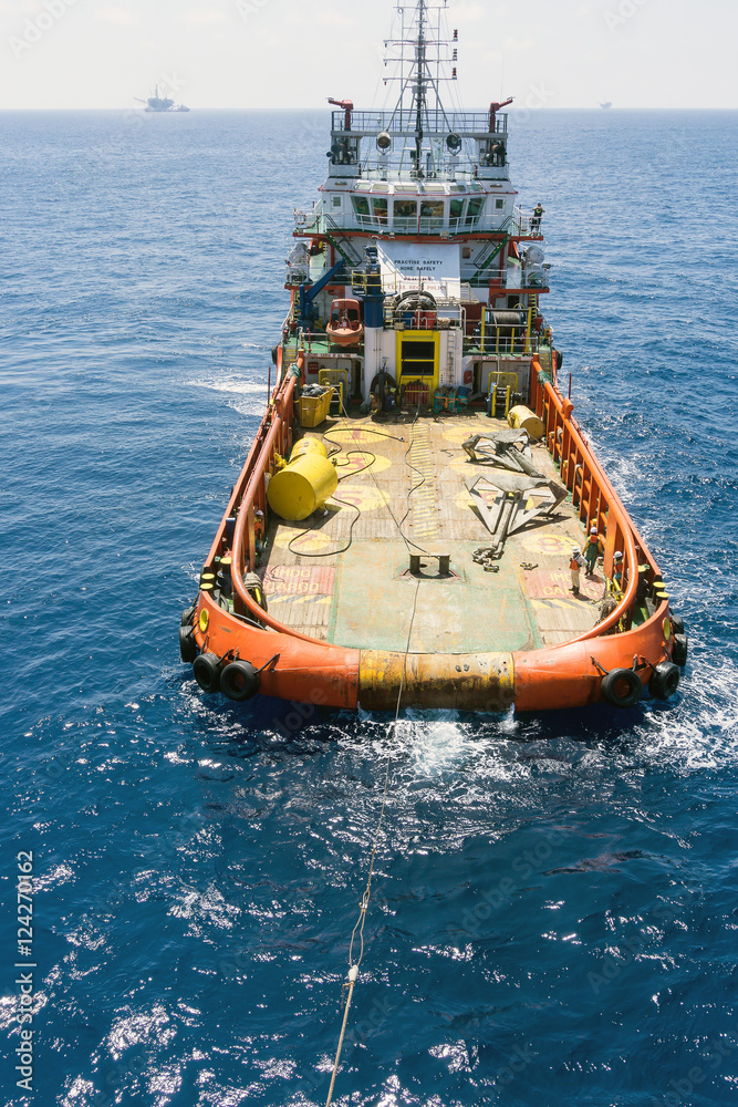 Offshore crew handling anchors on deck tugboat during anchor handling