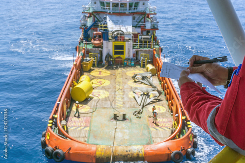 Offshore worker taking note while performing anchor handling operation at Terengganu oilfield, Malaysia