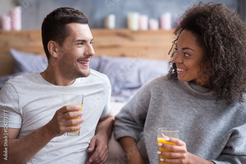 Smiling couple drinking juice together in the morning
