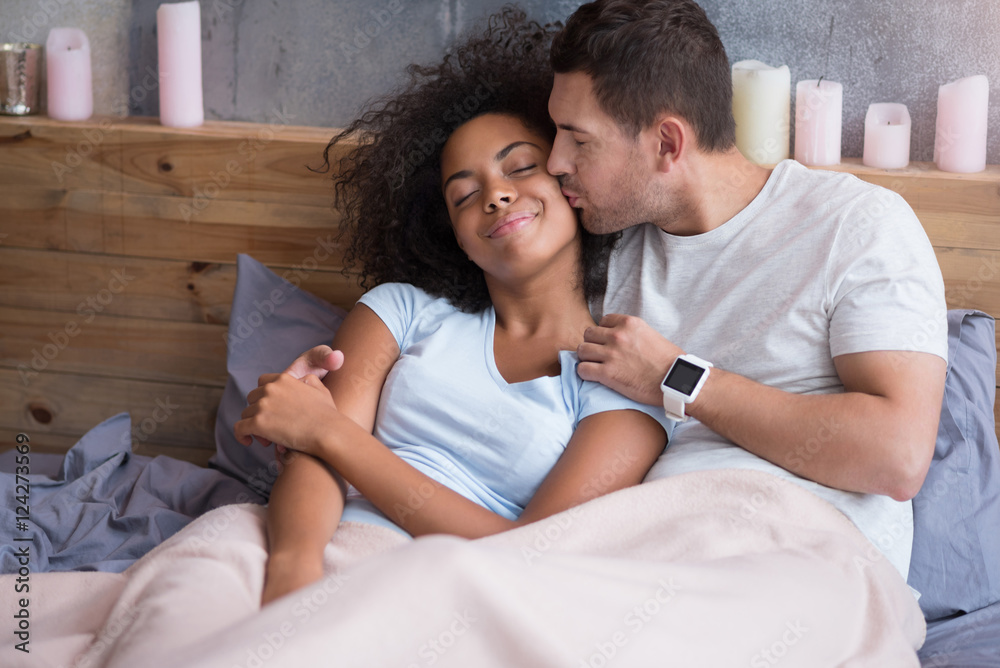Young man kissing his girlfriend tenderly Young man kissing his girlfriend tenderly