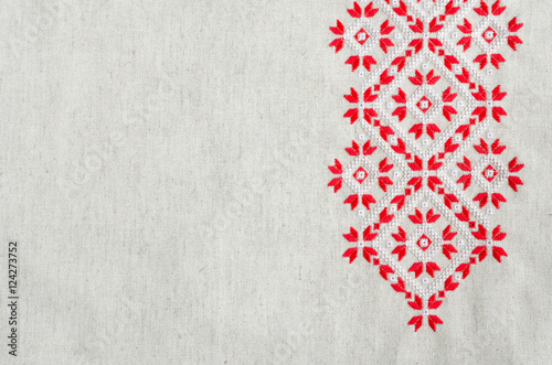 Embroidery design by red and white cotton threads on flax. Christmas background with embroidery.