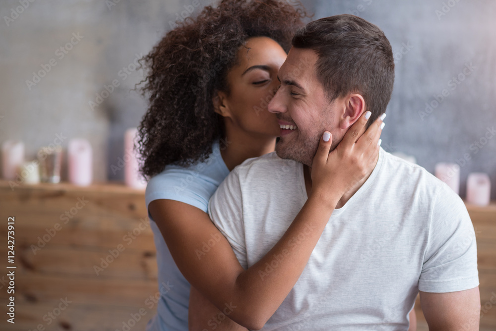 Happy girl giving a kiss to her delighted husband Happy girl giving a kiss to her delighted husband