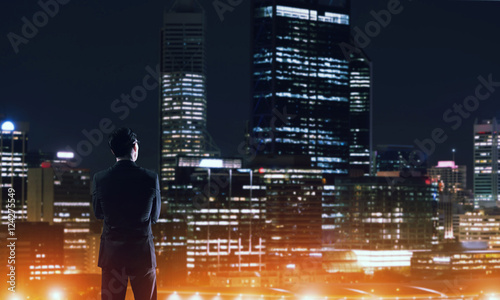 Businessman viewing night glowing city