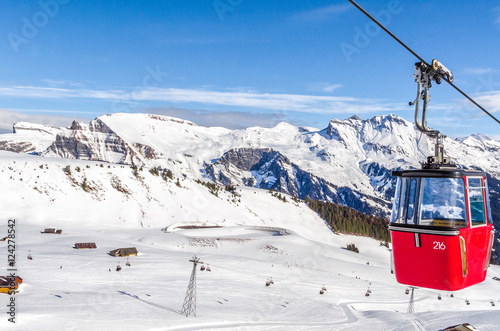 ski slope in Swiss Alps in sunny day. Red cableway