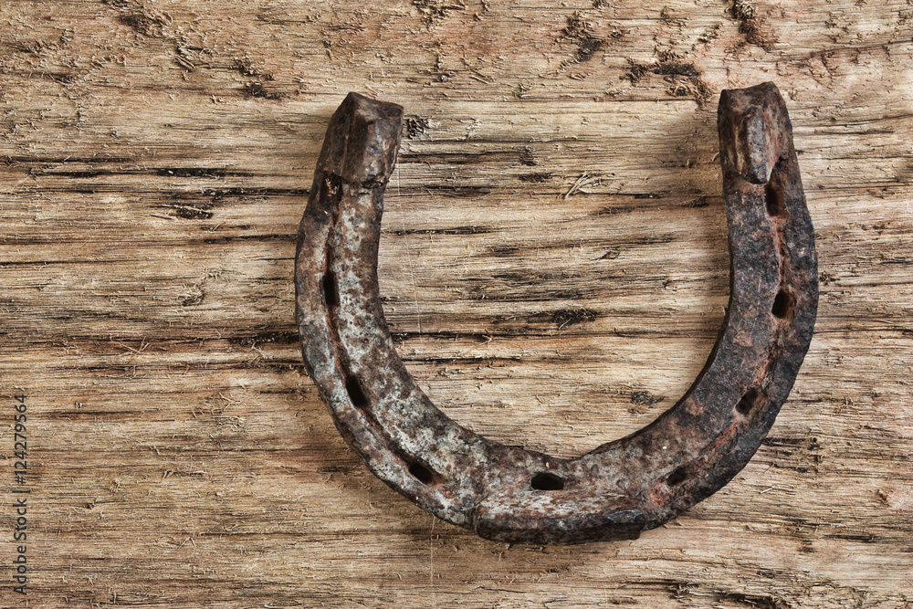 old rusty horseshoe on a wood background