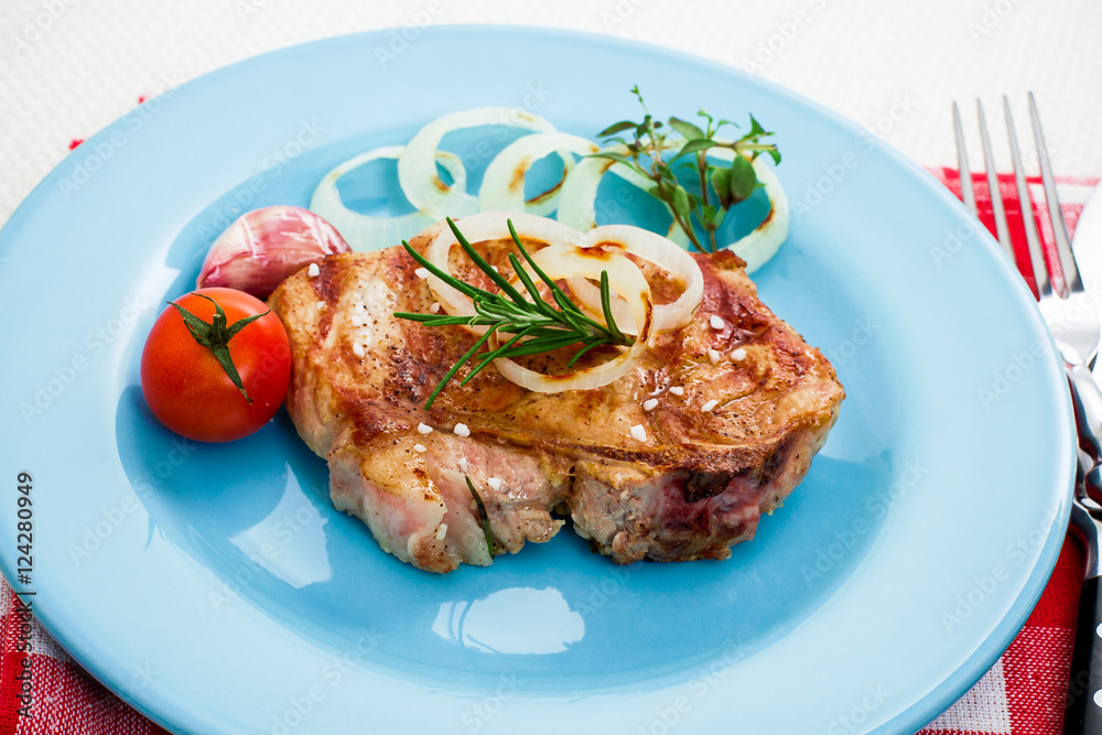 Juicy grilled pork chop with onion rings