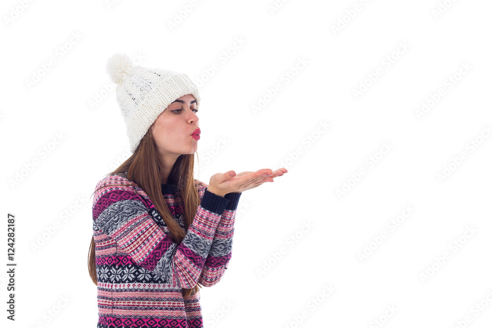 Woman in sweater and white hat blowing Woman in sweater and white hat blowing