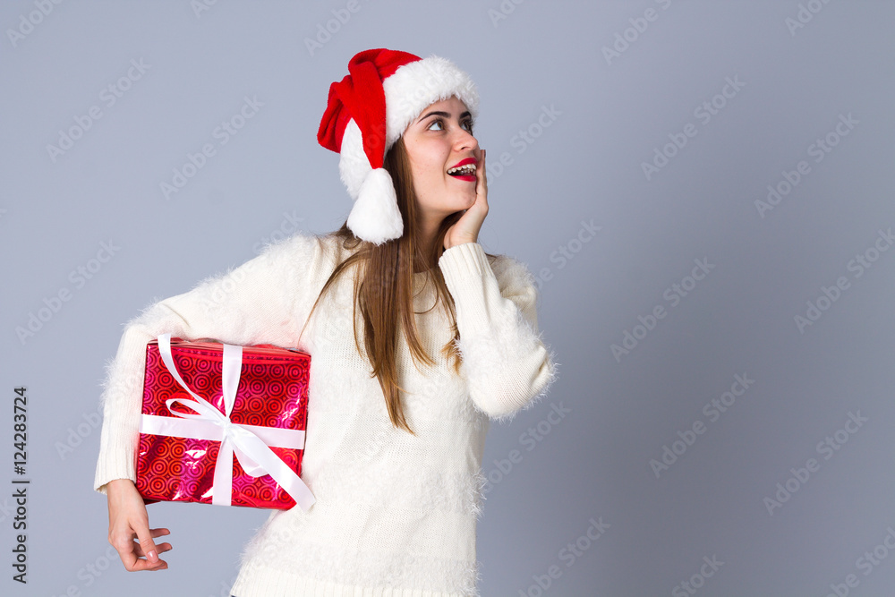 Woman in red christmas hat holding presents Woman in red christmas hat holding presents