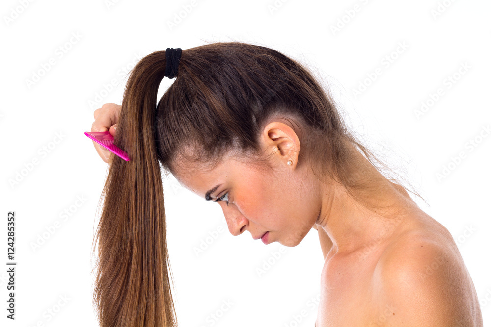 Fototapeta premium Young woman combing her long ponytail