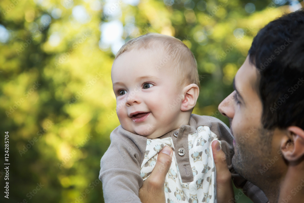 Father holding his young son outdoors in autumn; Edmonton, Alberta, Canada Father holding his young son outdoors in autumn; Edmonton, Alberta, Canada