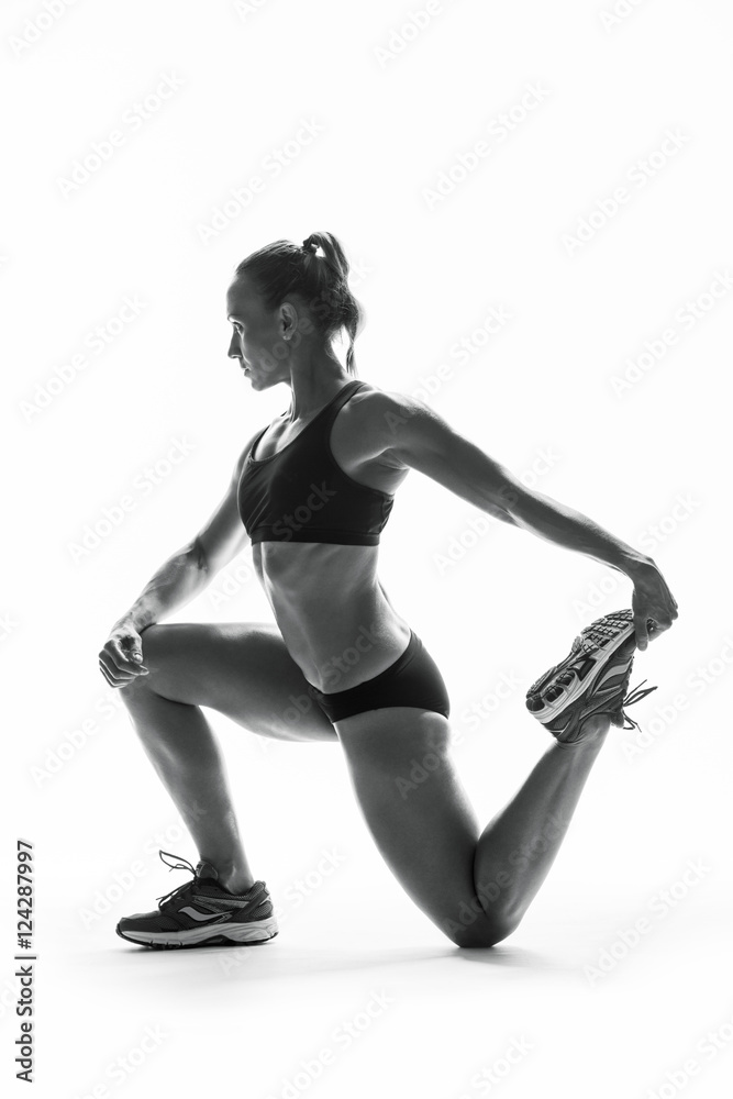 Athletic young woman doing stretching fitness exercise, isolated. Intense stretch pose Athletic young woman doing stretching fitness exercise, isolated. Intense stretch pose