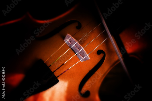 Detail of a violin on a blurry dark background, selected focus, very narrow depth of field