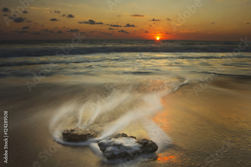 Waves over rocks on the beach at sunset; Mazatlan, Mexico photo