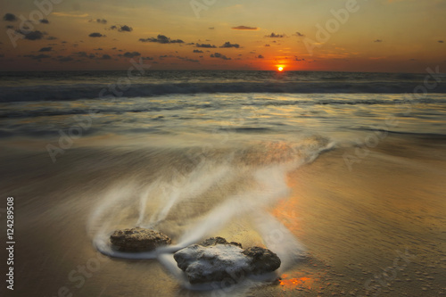 Waves over rocks on the beach at sunset; Mazatlan, Mexico