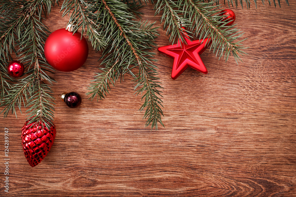 Red Christmas ornaments and fir tree branch on a rustic wooden background. Xmas card. Happy New Year. Top view with copy space Red Christmas ornaments and fir tree branch on a rustic wooden background. Xmas card. Happy New Year. Top view with copy space