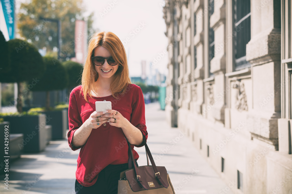 Fototapeta premium Pretty woman using cellphone outdoors.