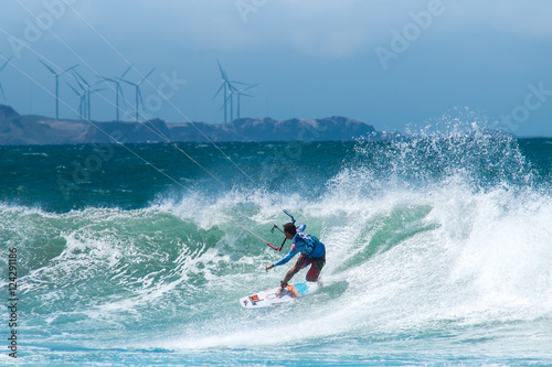 Amazing kite surfing at Philippines. Processional instructor surfing in ocean waives near windmills