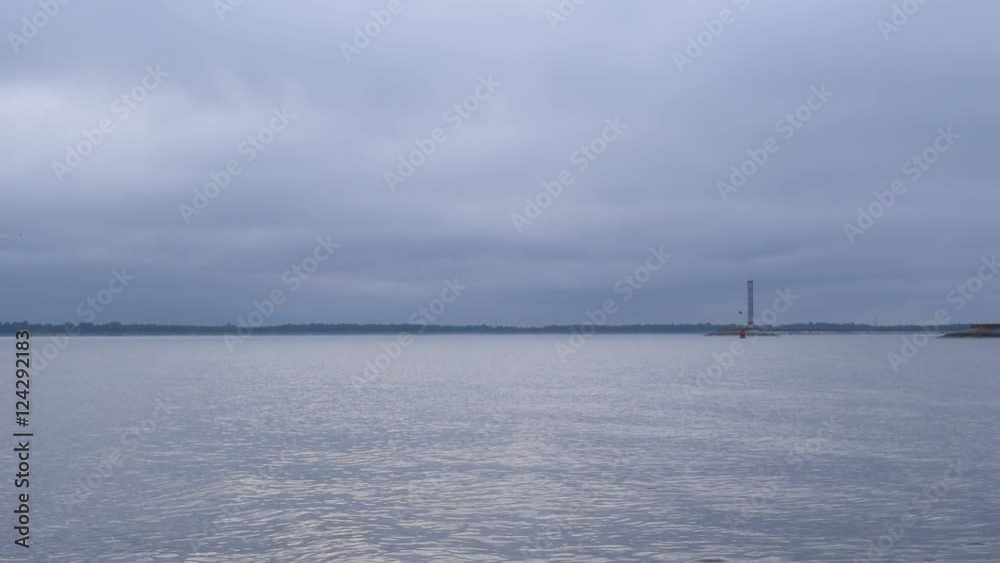 Bird flies above calm light blue water surface above sea, lake or river Bird flies above calm light blue water surface above sea, lake or river