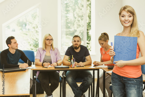 Student girl in front of her mates in classroom