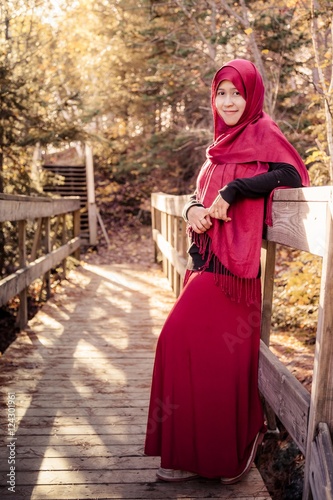 A pregnant muslim woman with natural background during autumn season