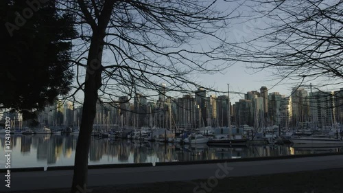 Dolly shot of harbour with boats and Vancouver skyline at dusk. photo