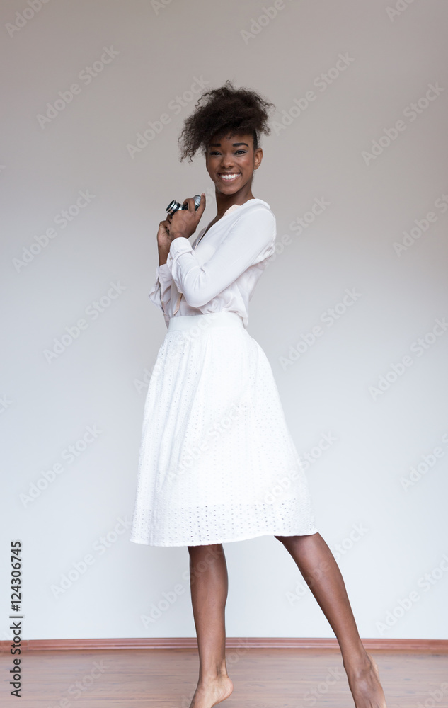 Naklejka premium Afro american woman holding vintage camera and taking photograph