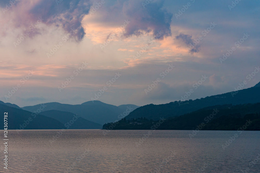 Caldera lake on dusk with mountain silhouettes on the background