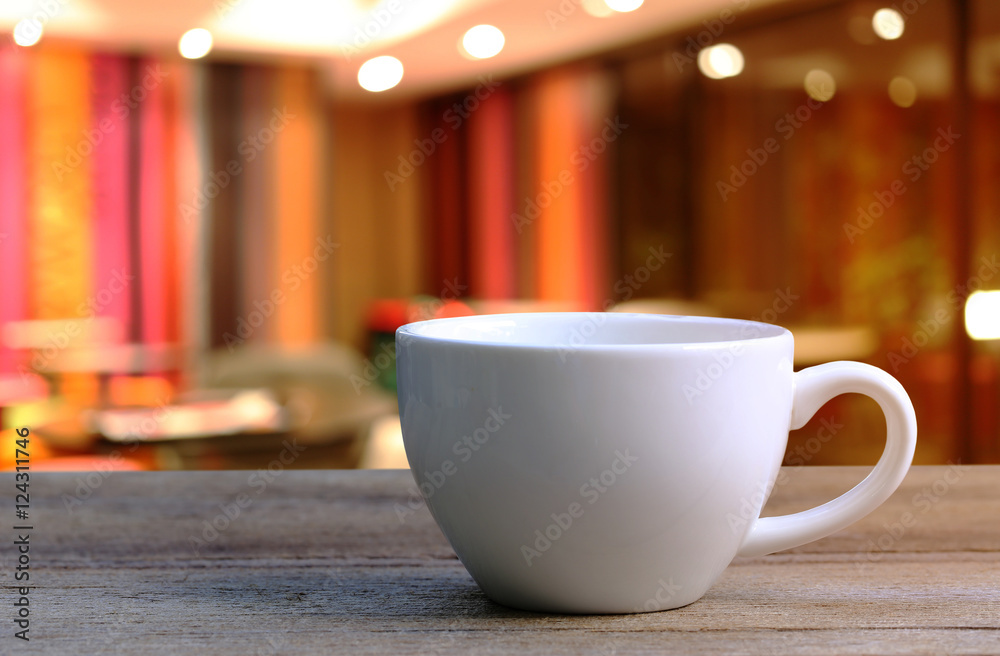 White Coffee cup on wooden table in coffee shop blur background. White Coffee cup on wooden table in coffee shop blur background.