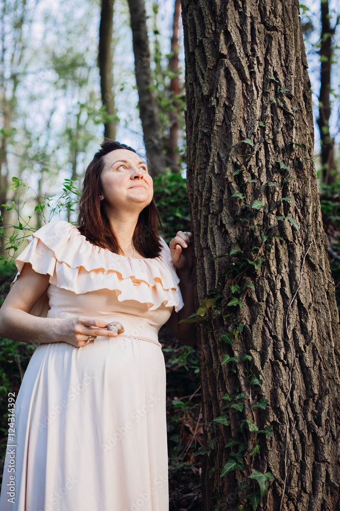 nice and gentle pregnant woman standing in the forest nice and gentle pregnant woman standing in the forest