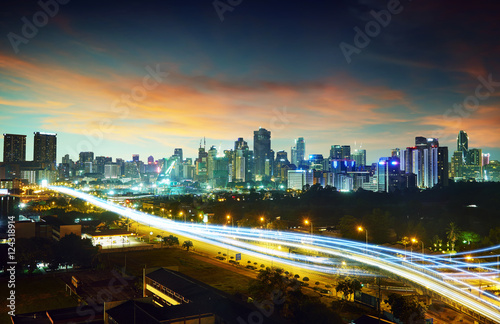 Abstract and car lighttrail background, city skyline downtown background and highway interchanged nigh view .