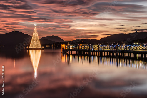 Obraz na plátne Christmas tree on Lake Woerthersee during colorful sunset