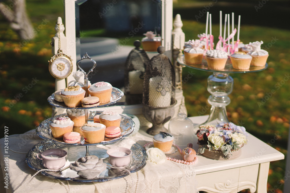 wedding candy bar with white cupcakes on decorated table