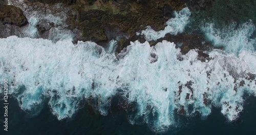 A vertical aerial of big swells breaking againt a rugged rocky shore  at  Shark Bay in Western Australia