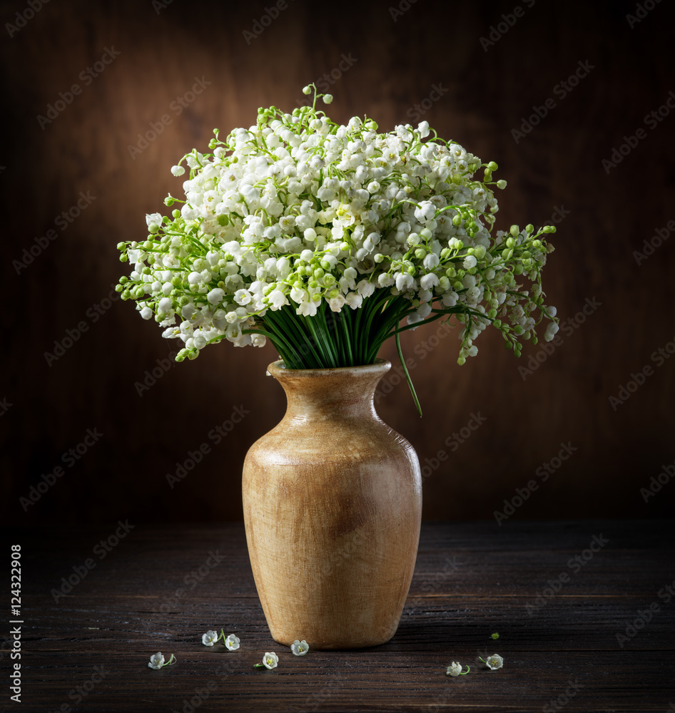 Fototapeta premium Lily of the valley bouquet on the wooden table.