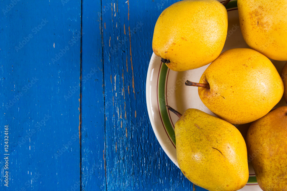 Fresh ripe organic yello pears on blue rustic wooden table, natural background, diet food.