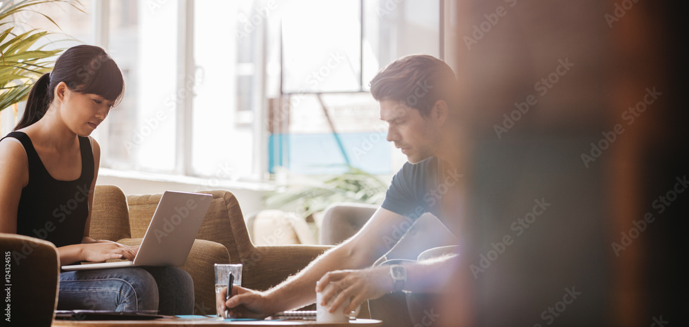 Two young businesspeople sitting together in a cafe Two young businesspeople sitting together in a cafe