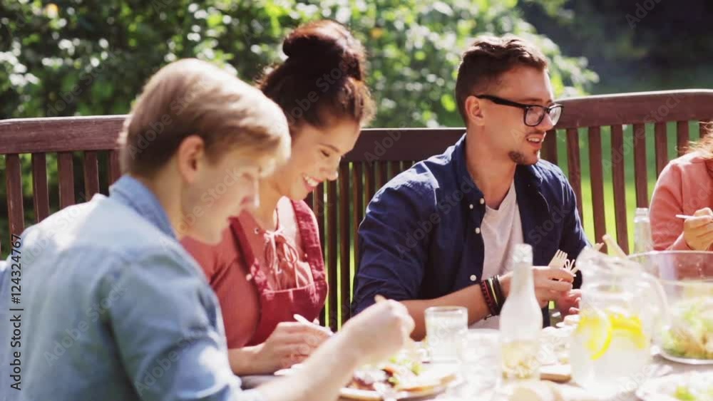 happy friends having dinner at summer garden party