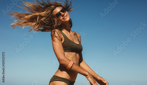 Canvas Print Beautiful woman against blue sky with fluttering hair