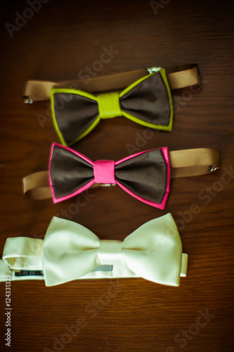 Different colored bright bow ties lie on the table