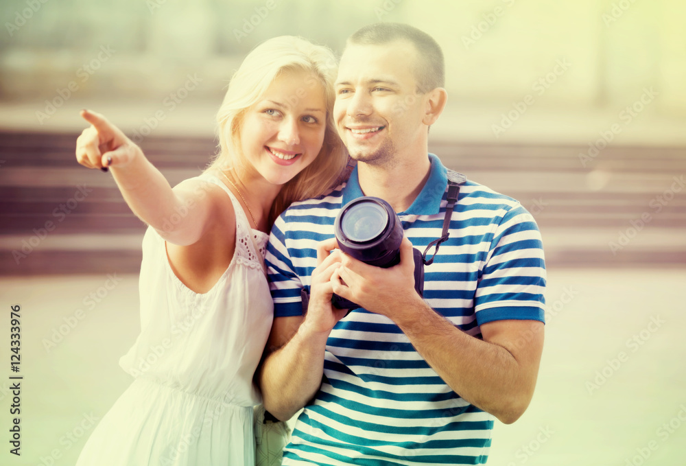 young couple taking pictures outdoors.