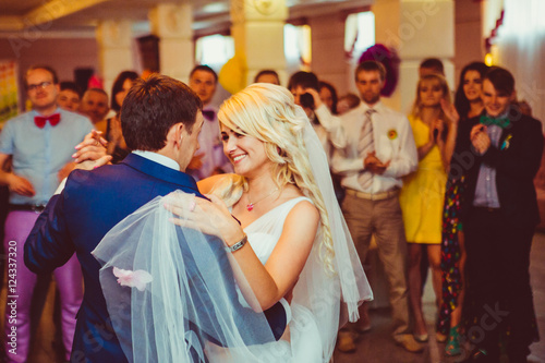 Bride lies her hand over groom's shoulder while dancing in the c